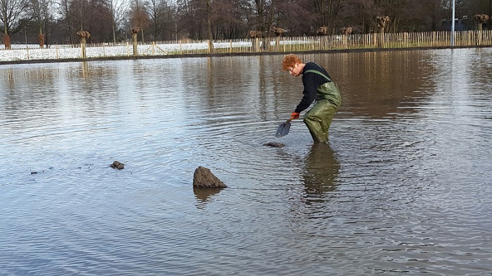 Spitten om de bagger onder water te krijgen Bagger omspitten om het onder water te krijgen